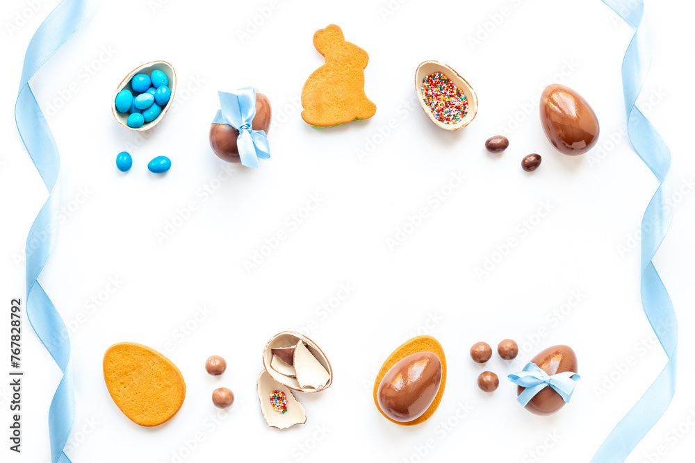 Happy Easter card. Chocolate Easter eggs in blue ribbon with bunny cookies Happy Easter card. Chocolate Easter eggs in blue ribbon with bunny cookies