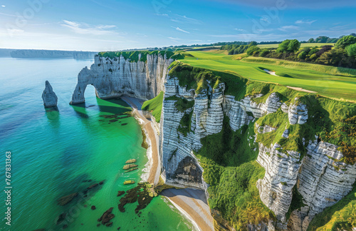 A panoramic view of the rugged cliffs and lush green meadows at etretat, with clear blue waters below, a golf course in the distance, and a quaint village nestled on its path to coastline