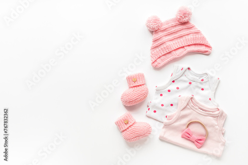 Set of baby girl dress - bodysuit with knitted hat and boots, top view. Kids clothing flat lay