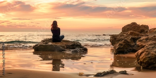 Solitary woman sits on a rock, gazing at a serene sunset over a calm sea, the sky painted with hues of gold and rose.