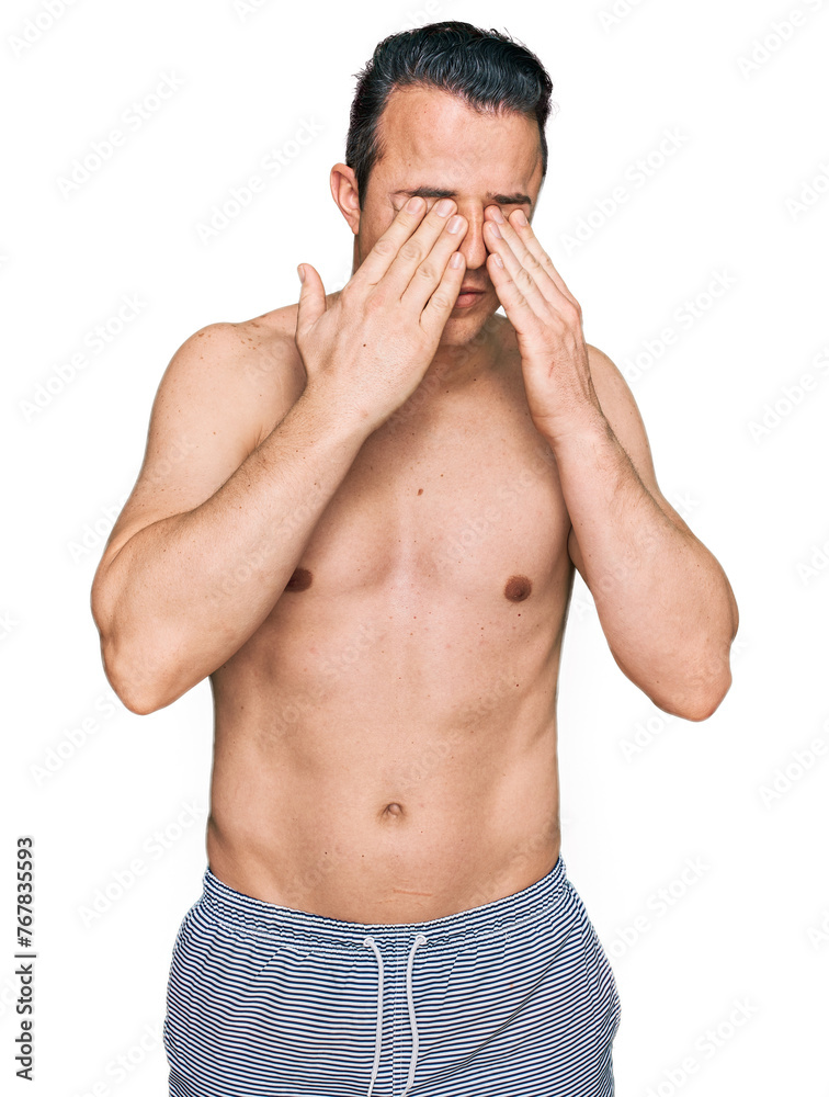 Handsome young man wearing swimwear shirtless rubbing eyes for fatigue and headache, sleepy and tired expression. vision problem