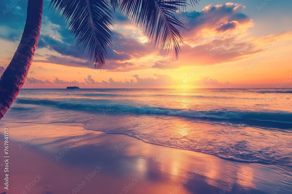 A palm tree stands in the foreground as the sun sets over a tropical beach.