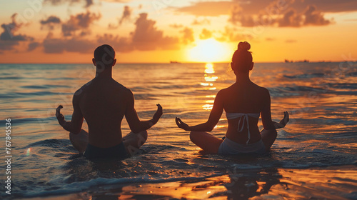 Young couple practicing yoga together at golden sunset beach © Stone Story
