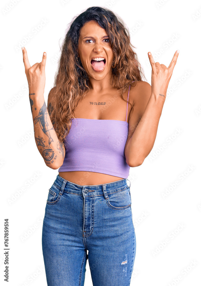 Young hispanic woman with tattoo wearing casual clothes shouting with crazy expression doing rock symbol with hands up. music star. heavy music concept. Young hispanic woman with tattoo wearing casual clothes shouting with crazy expression doing rock symbol with hands up. music star. heavy music concept.