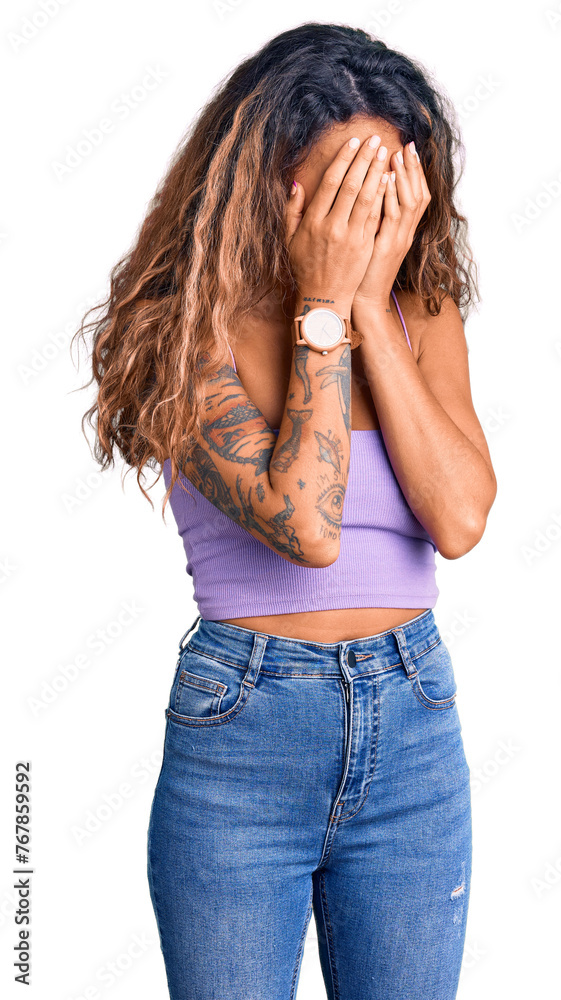 Young hispanic woman with tattoo wearing casual clothes with sad expression covering face with hands while crying. depression concept. Young hispanic woman with tattoo wearing casual clothes with sad expression covering face with hands while crying. depression concept.