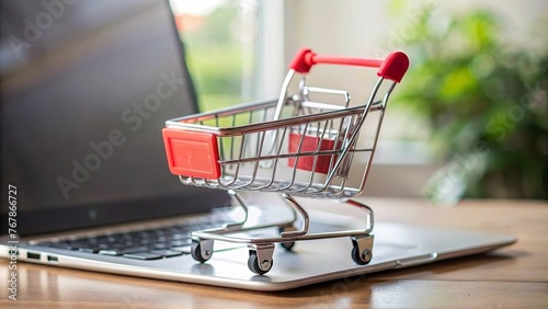 A miniature shopping cart placed on an open laptop keyboard, illustrating the concept of online shopping and e-commerce