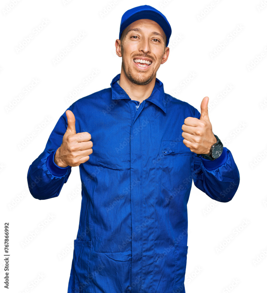 Bald man with beard wearing builder jumpsuit uniform success sign doing positive gesture with hand, thumbs up smiling and happy. cheerful expression and winner gesture. Bald man with beard wearing builder jumpsuit uniform success sign doing positive gesture with hand, thumbs up smiling and happy. cheerful expression and winner gesture.