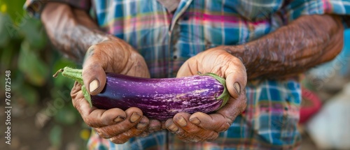 Grass-covered farmer in Guatemala with an eggplant.