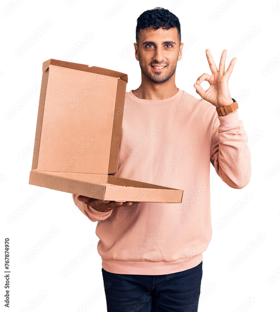Young hispanic man holding delivery pizza box doing ok sign with fingers, smiling friendly gesturing excellent symbol Young hispanic man holding delivery pizza box doing ok sign with fingers, smiling friendly gesturing excellent symbol
