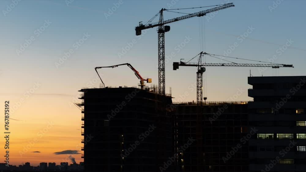 Construction in progress. Time lapse of a breathtaking view to the construction site with silhouettes of cranes and a lot of workers on the sunset sky background. Aerial view
Construction in progress. Time lapse of a breathtaking view to the construction site with silhouettes of cranes and a lot of workers on the sunset sky background. Aerial view