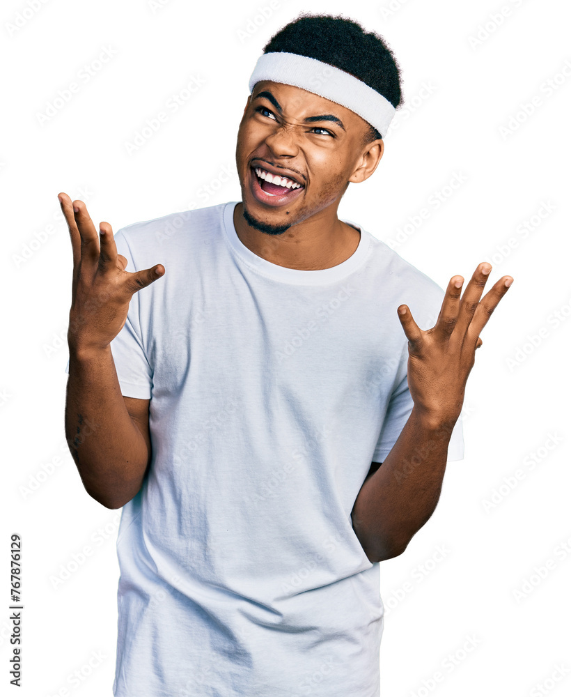 Naklejka premium Young african american man wearing sportswear crazy and mad shouting and yelling with aggressive expression and arms raised. frustration concept.