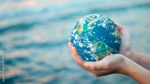 holds a global in their hand while standing in water. Concept of responsibility and awareness towards the environment, Sustainable development