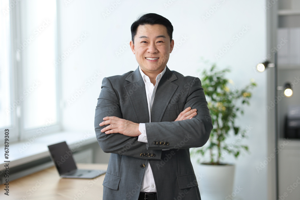 Portrait of smiling businessman with crossed arms in office Portrait of smiling businessman with crossed arms in office