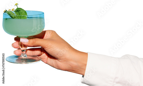 Female hand in green festive outfit holding glass with cocktail against transparent background. Concept of party, relax, alcohol, holidays, celebrations, Friday mood.