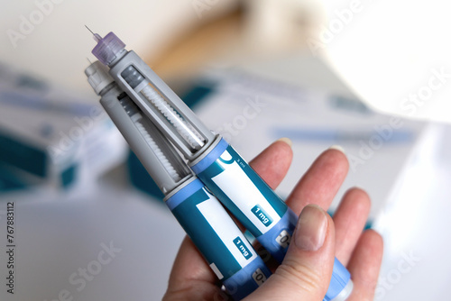 Hand holding Ozempic Insulin injection pen for diabetics.