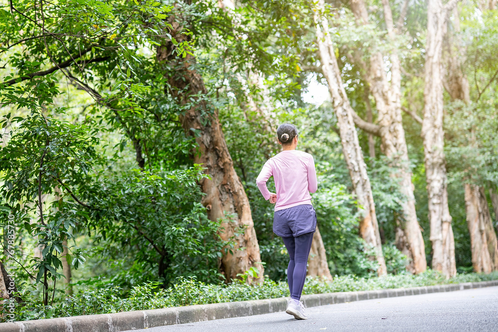 Back view of woman exercising and jogging in park Back view of woman exercising and jogging in park