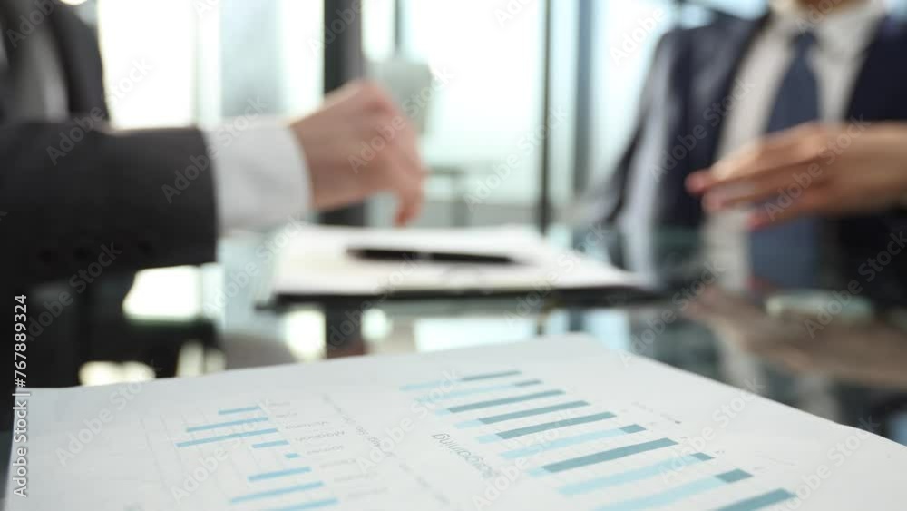 Businessmen shake hands in close-up at the office table