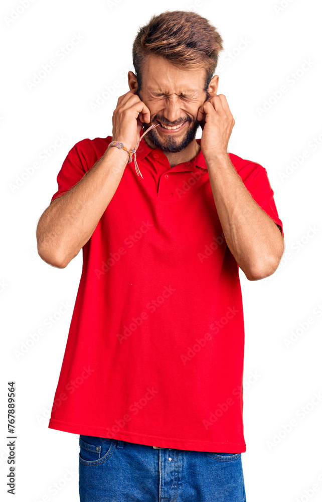 Handsome blond man with beard wearing casual clothes covering ears with fingers with annoyed expression for the noise of loud music. deaf concept. Handsome blond man with beard wearing casual clothes covering ears with fingers with annoyed expression for the noise of loud music. deaf concept.