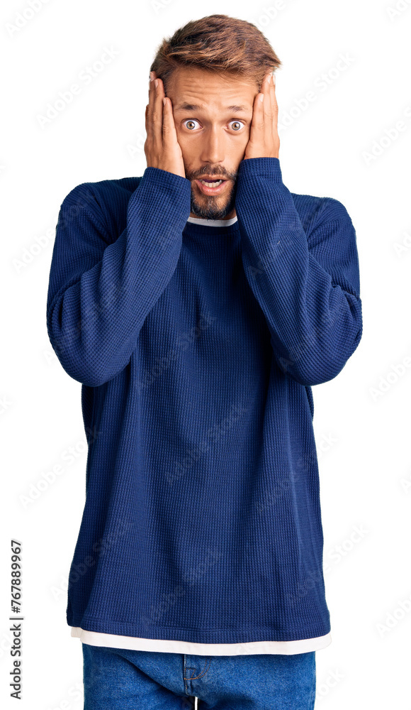 Handsome blond man with beard wearing casual sweater afraid and shocked, surprise and amazed expression with hands on face Handsome blond man with beard wearing casual sweater afraid and shocked, surprise and amazed expression with hands on face