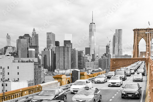 Brooklyn Bridge isolated in color against a black and white view of downtown Manhattan and its skyscrapers, New York
