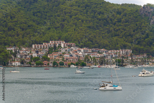 View of Fethiye Bay with yachts, houses, mountains on a cloudy day, Turkey