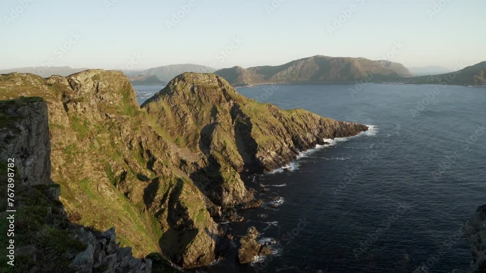 steep cliffs in the landscape of Runde island during sunset at the coastline of the north atlantic ocean in Norway, a popular travel destination for bird watching. steep cliffs in the landscape of Runde island during sunset at the coastline of the north atlantic ocean in Norway, a popular travel destination for bird watching.