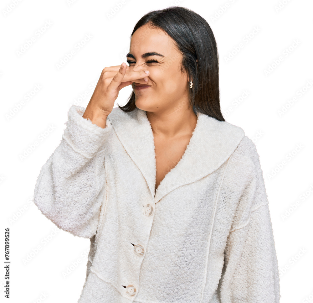 Young brunette woman wearing casual clothes smelling something stinky and disgusting, intolerable smell, holding breath with fingers on nose. bad smell Young brunette woman wearing casual clothes smelling something stinky and disgusting, intolerable smell, holding breath with fingers on nose. bad smell