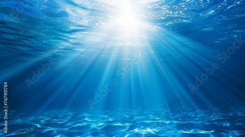 Ocean background - Sun shining light sunlight sunshine in blue clearly deep water, sunbeams illuminate the blue underwater sea scene © Corri Seizinger