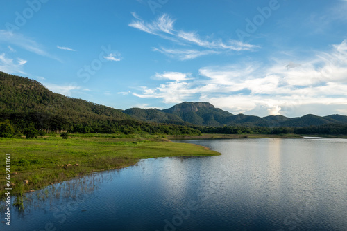 Serene Lake with Lush Hills Under a Blue Sky
