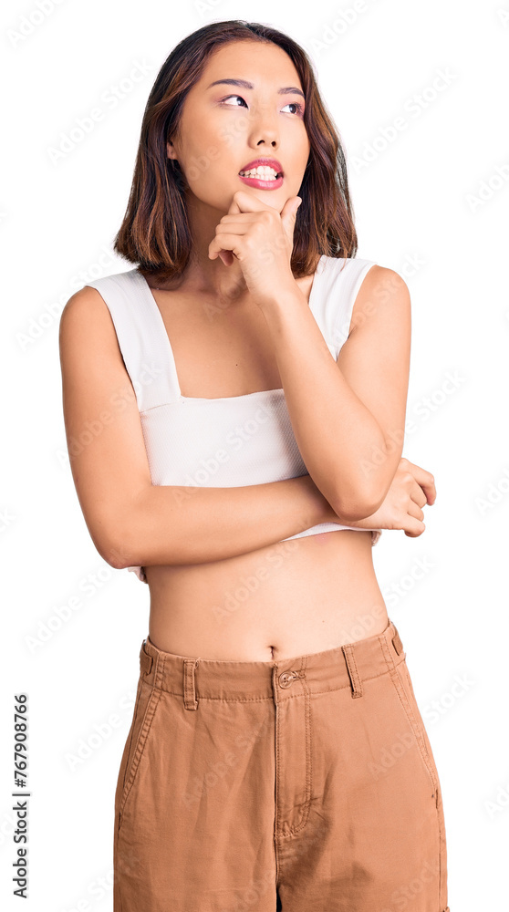 Young beautiful chinese girl wearing casual clothes with hand on chin thinking about question, pensive expression. smiling with thoughtful face. doubt concept. Young beautiful chinese girl wearing casual clothes with hand on chin thinking about question, pensive expression. smiling with thoughtful face. doubt concept.