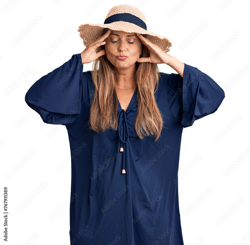 Middle age hispanic woman wearing summer hat with hand on head for pain in head because stress. suffering migraine. Middle age hispanic woman wearing summer hat with hand on head for pain in head because stress. suffering migraine.