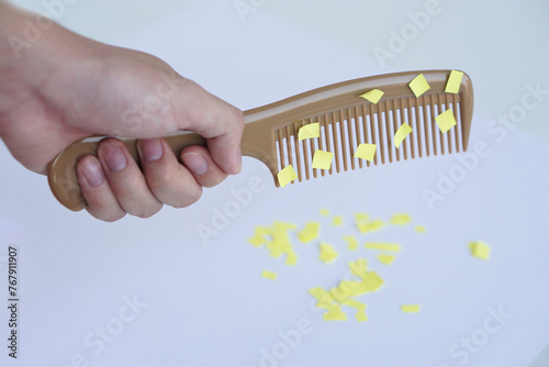 Hand holds comb and small pieces of paper. Equipment, prepared to do experiment about static electricity. Concept, Science lesson, fun and easy experiment. Education. Teaching aids.      