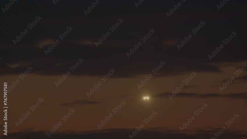 The plane is right in front of the viewer, its headlights create a bright flash in the center, surrounded by a twilight sky with clouds The plane is right in front of the viewer, its headlights create a bright flash in the center, surrounded by a twilight sky with clouds
