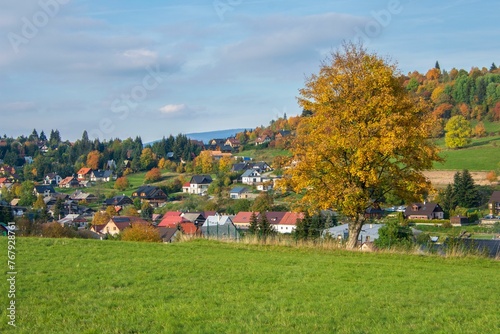 Rural autumn landscape with a green meadow against the background of a village. Krahule, Slovakia. photo