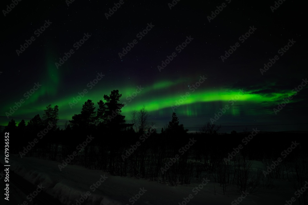 Landscape of a hill covered in snow during the Northern Lights