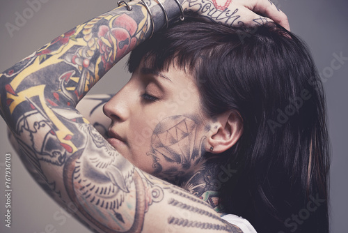Fotografie Tattoo, culture and rebel with woman, punk rock and tradition on a grey studio background