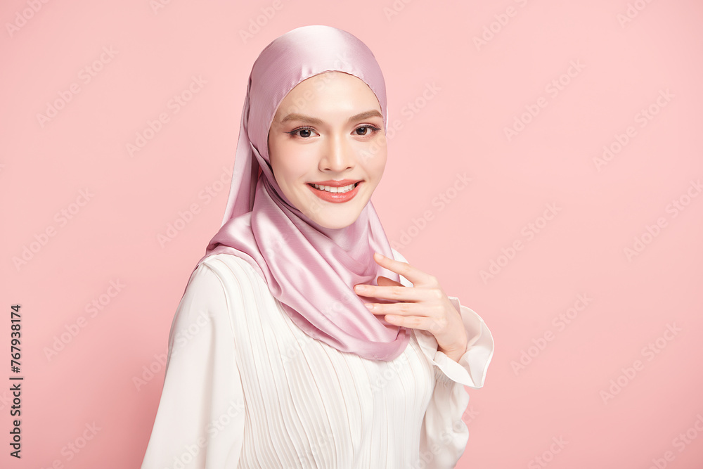 Beautiful young asian muslim woman wearing a pink hijab on pink background, Portrait of Arab Beauty. Beautiful young asian muslim woman wearing a pink hijab on pink background, Portrait of Arab Beauty.