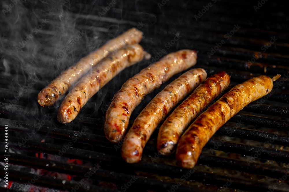 Grilling sausages on the grill with flames and smoke. Grilling sausages on the grill with flames and smoke.