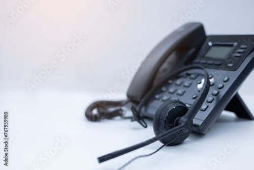 close up soft focus on telephone devices with copy space white background at office desk in operation room for customer service support (call center) concept