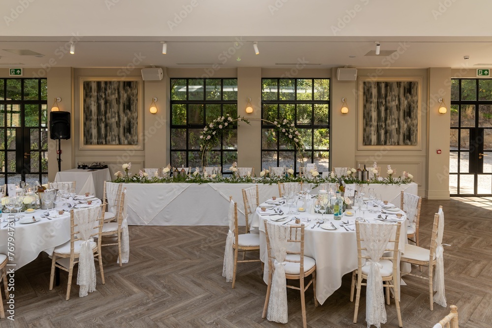 Empty wedding reception area set up with tables, ready for guests to arrive Empty wedding reception area set up with tables, ready for guests to arrive