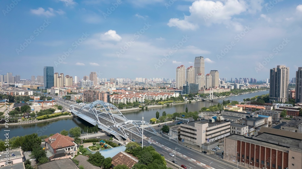 View of a the Zhigu Bridge over Haihe River with urban buildings and landmarks in Tianjin, China