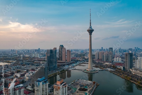 Aerial shot of Tianjin TV Tower and Water Park Complex near water in China at sunset