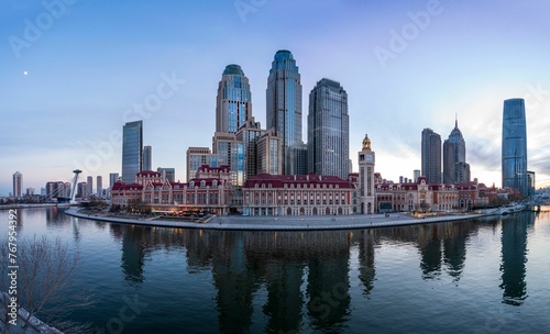 Aerial shot of an urban skyline with landmarks along the Haihe River in Tianjin, China at sunset © Wirestock