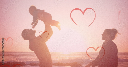 Image of hearts falling over caucasian family at beach