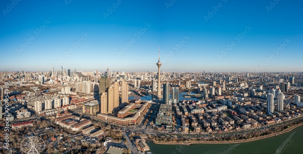 View of the Tianjin TV Tower and Water Park Complex near a body of water in China at sunset
