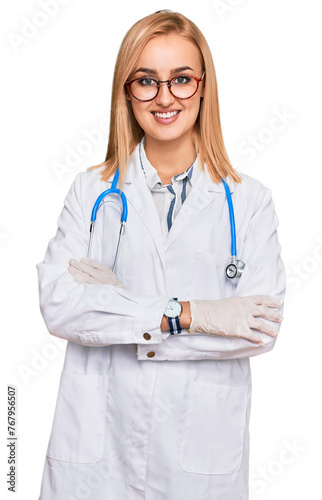 Beautiful caucasian woman wearing doctor uniform and stethoscope happy face smiling with crossed arms looking at the camera. positive person.