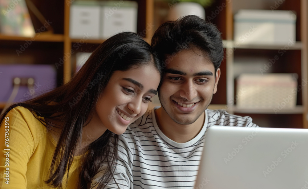 Happy Young Indian Couple Choosing Online Tutorials On Laptop For Home Training