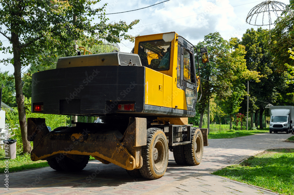 Yellow tractor in the park. Heavy duty construction equipment parked at work site Yellow tractor in the park. Heavy duty construction equipment parked at work site