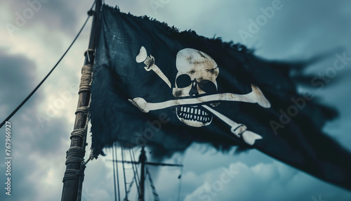 The Jolly Roger flag - bearing the infamous skull and crossbones - waves in the wind as the pirate ship sails into the horizon wide photo