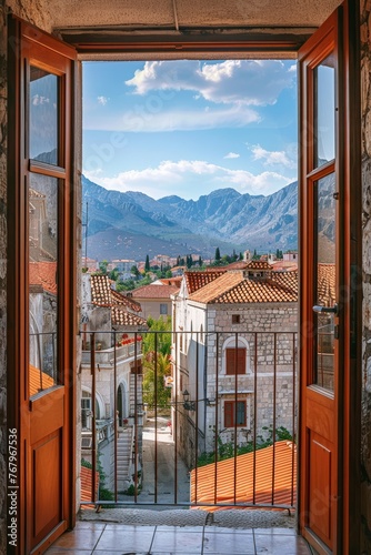 A quaint European village and a picturesque mountain landscape through an open window